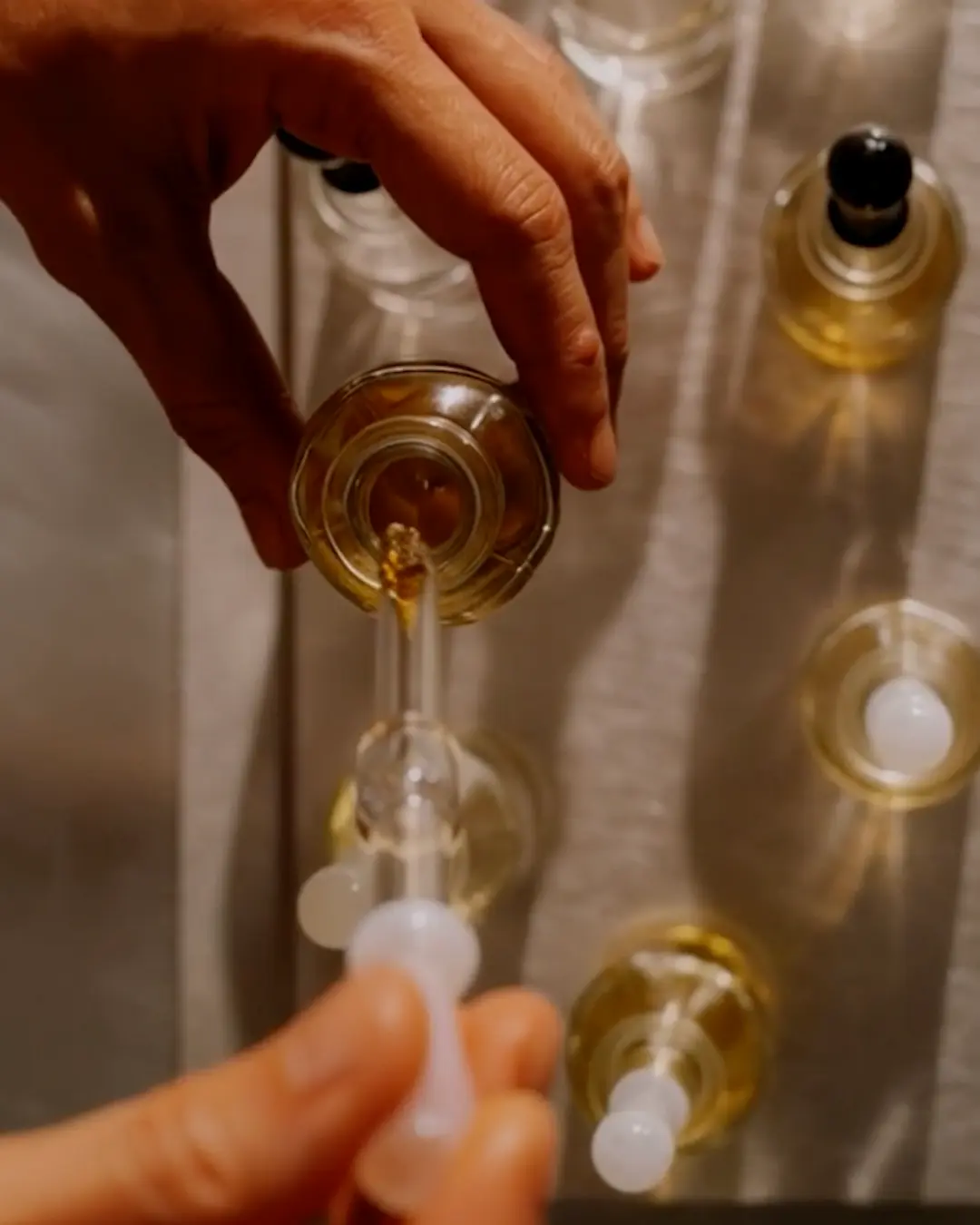 Hand pouring essential oil from bottle